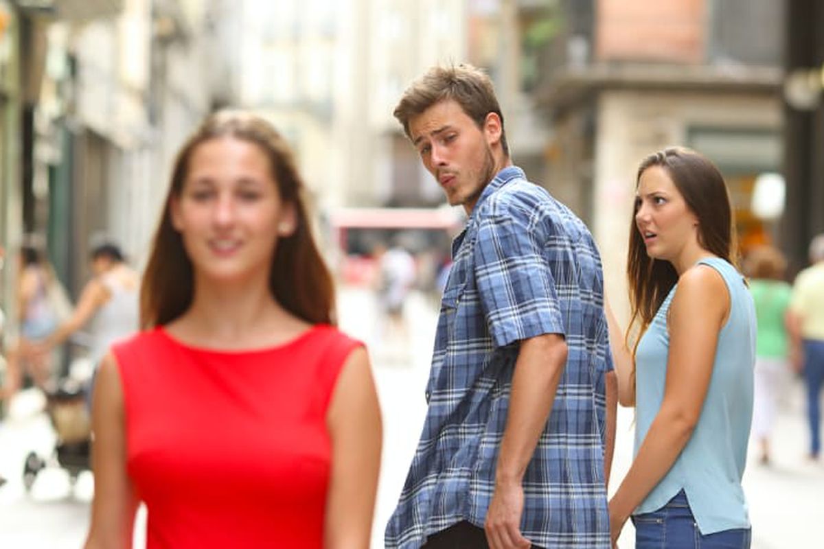 Distracted Boyfriend meme: a man turns to look at another woman while his girlfriend stares at him